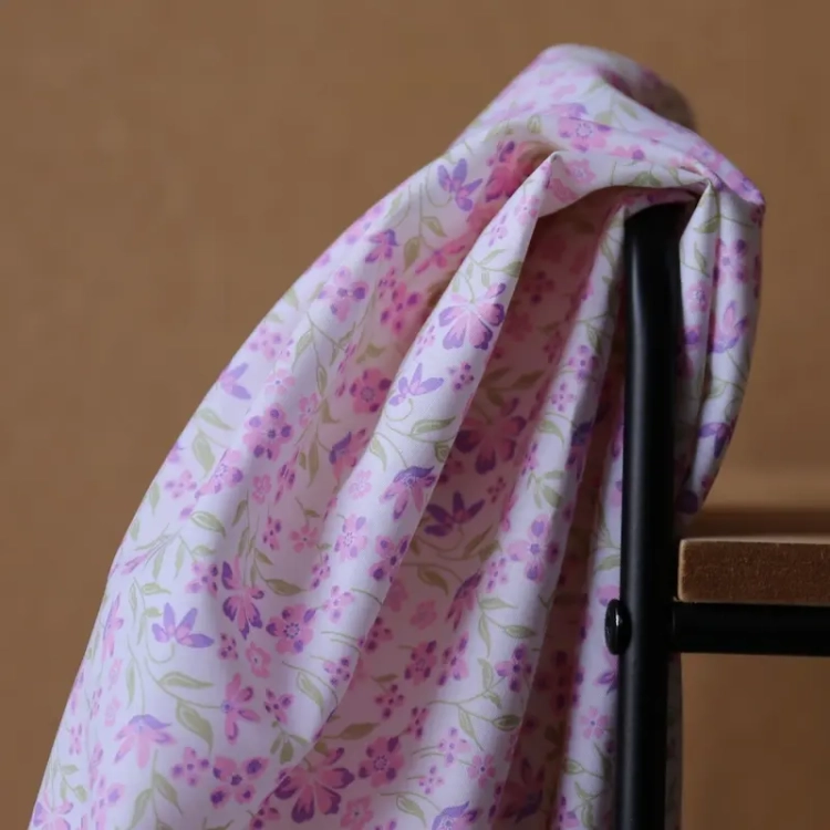 Fioletowa popelina bawełniana w gęsty wzór drobnych lawendowych kwiatów i zielonych listków o gładkim splocie.