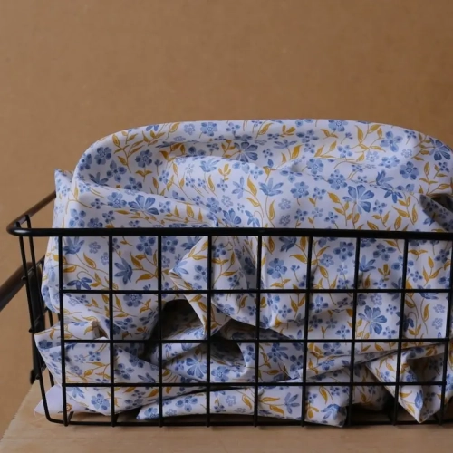 Niebieska popelina bawełniana Poppy Fabrics w gęsty wzór drobnych kwiatów i musztardowych listków o gładkim splocie.