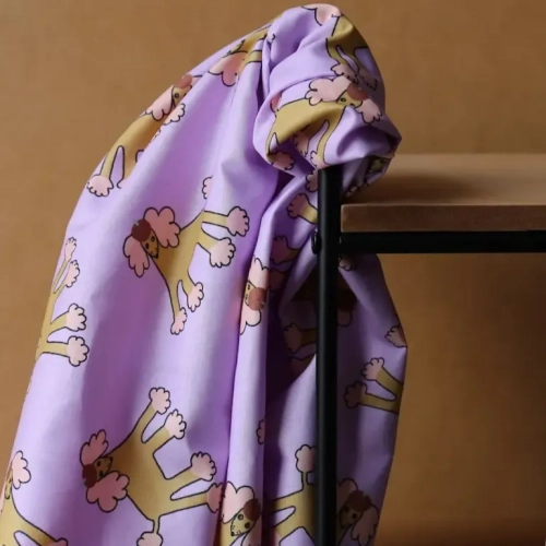 Popelina Paris Poodle Lawendowa 135 g/m² – tkanina w pastelowy nadruk z pudlami na sukienki i odzież dziecięcą