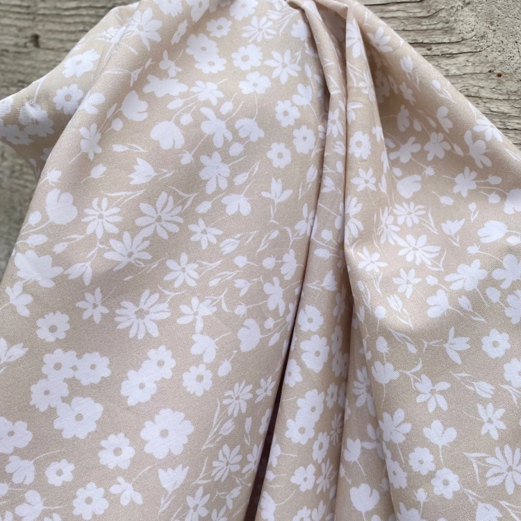 Delikatna tkanina w kwiatki na beżowym tle